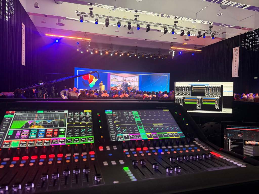Professional event production control console overlooking a live stage